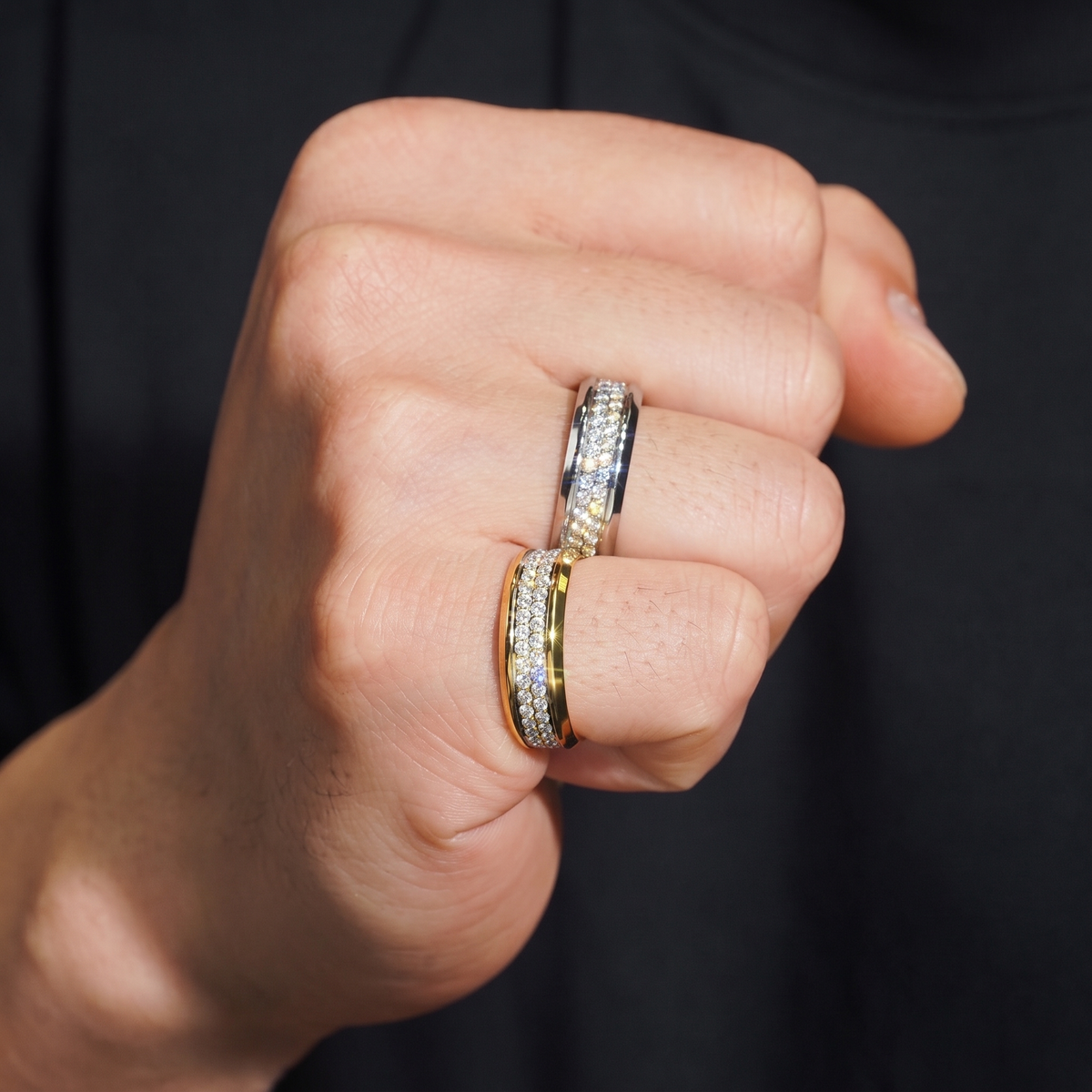 Double row pave bands worn on hand, gold and silver stacked on two fingers