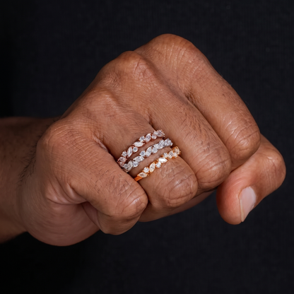 Three stacked marquise moissanite eternity band rings worn on a closed fist