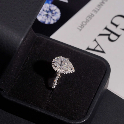 Pear cut moissanite halo ring in ring box with report