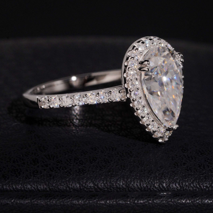 Pear cut moissanite ring side view showing halo and pave band