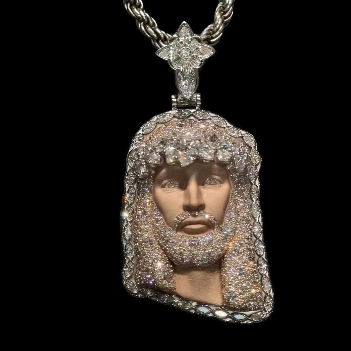 Moissanite Jesus head pendant hanging from a silver rope chain, marquise cut border
